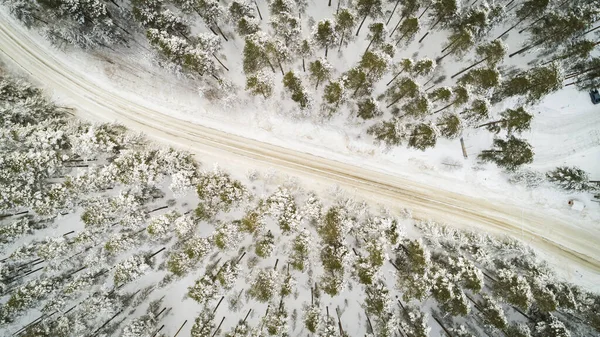 Aerial view of winter road. Winter landscape countryside. Aerial photography of snow forest with a car on the road. Captured from above with a drone. Aerial photography