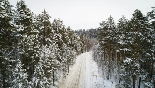Aerial view of a winter road. Winter landscape countryside. Aerial photography of snow forest. Captured from above with a drone. Aerial photography