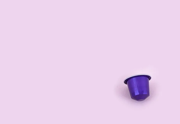 Фіолетова капсула кави над рожевим тлом — стокове фото