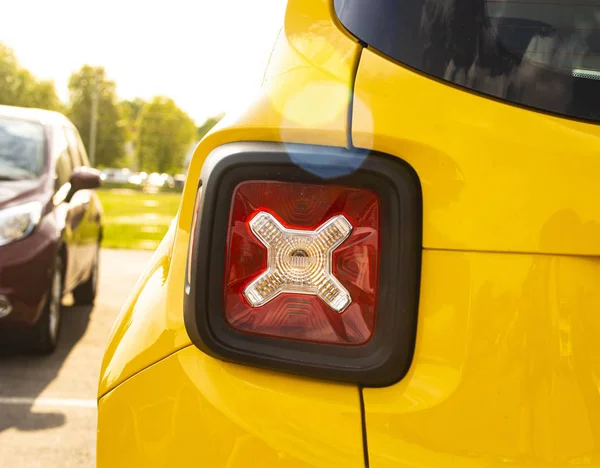 Luzes traseiras vermelhas de um carro amarelo estacionado — Fotografia de Stock