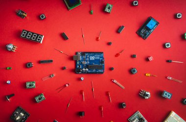 Sankt-Petersburg, Rusya - 28 Şubat 2020: Arduino UNO yönetim kurulu kırmızı zemin üzerinde. Mikro denetleyiciler, panolar, sensörler, kollar, kontrolörler, programlama için mikro denetleyici.