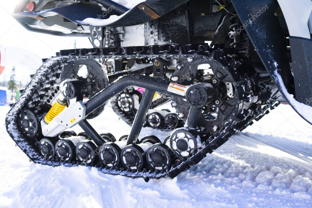 Close-up of a snowy caterpillar of a 6x6 snowmobile on the ski resort