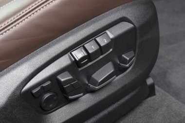 Lüks bir yolcu arabasının güç koltuğu kontrol düğmeleri. Lüks modern arabanın içi kırmızı deri. Modern araba iç dekorasyonu