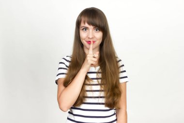 Bir parmak onun dudakları - sessiz jest tutan genç kadın.