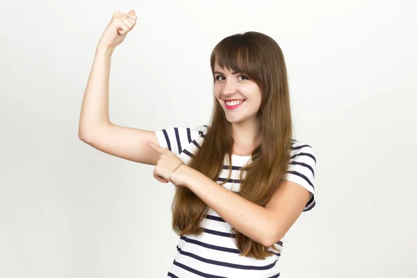 Freudig. sehr glückliche Frau zeigt auf die Muskeln — Stockfoto