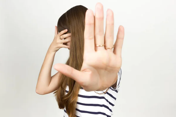 Frau verdeckt ihre Augen und zeigt per Hand ein Stoppsignal — Stockfoto