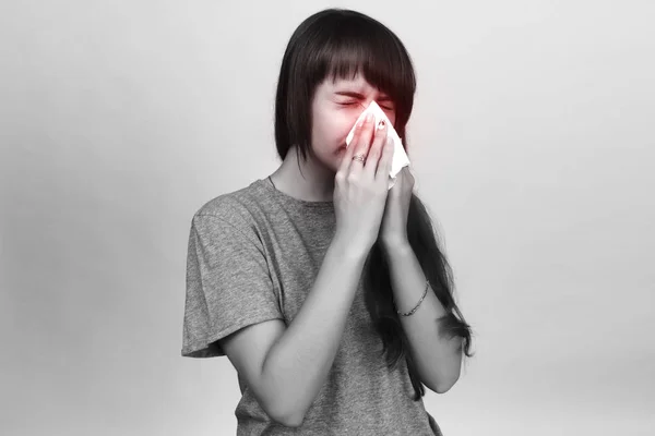 Porträt einer hübschen Frau mit Grippe. Mädchen pustet Nase. schwarz-weiß mit rotem Akzent. — Stockfoto