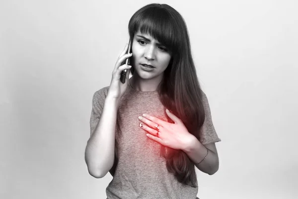 Schöne Frau mit Herzinfarkt oder gebrochenem Herzen. Einen Arzt rufen. — Stockfoto