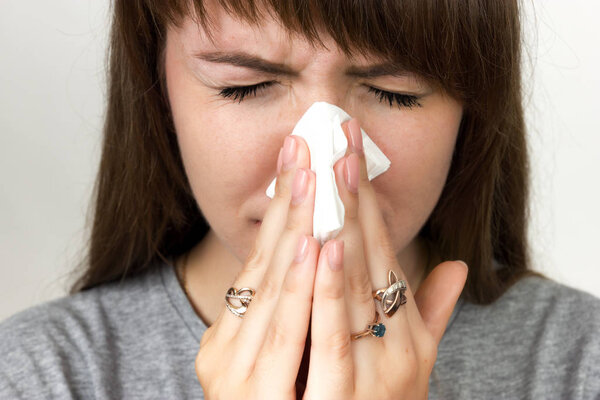 Портрет красивой женщины с гриппом. Девушка сморкается. Черно-белый с красным акцентом
.