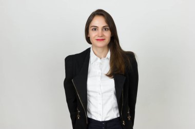 Gri arka plan üzerinde duran genç ve güzel bir işkadını portresi