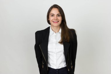 Gri arka plan üzerinde duran genç ve güzel bir işkadını portresi