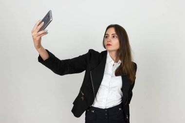 Genç ve güzel bir işkadını portresi o gülümsüyor ve selfie yapar 