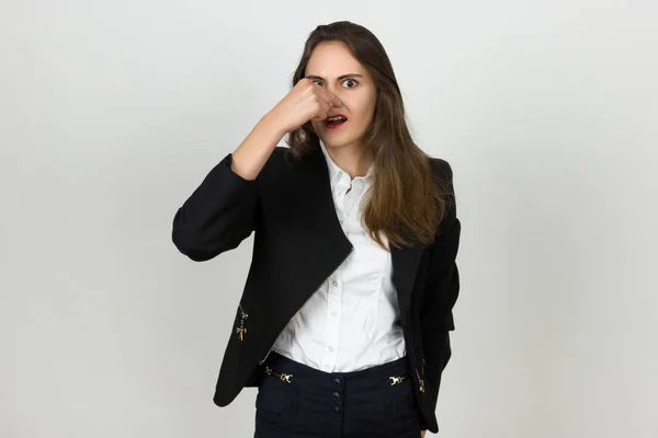 Junge Geschäftsfrau hält sich wegen schlechten Geruchs die Nase — Stockfoto