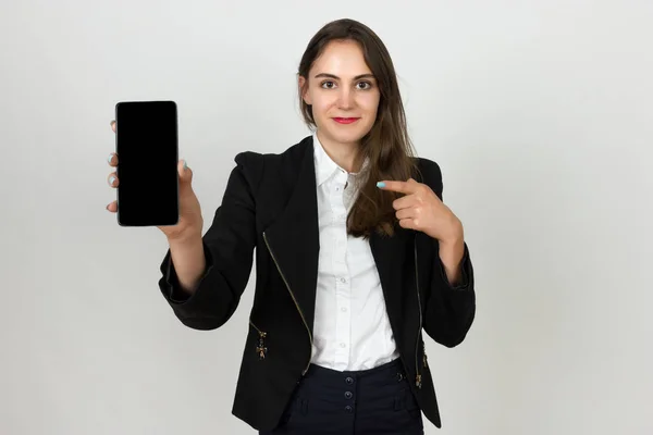 Genç iş kadını gösteren boş smartphone ekran gülümseyen ve üzerinde parmak işaret