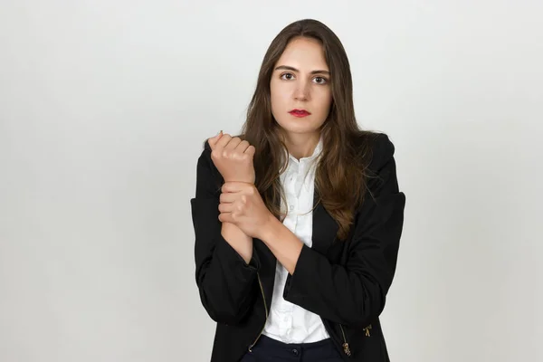 Junge Geschäftsfrau hält wundes Handgelenk in der Hand — Stockfoto