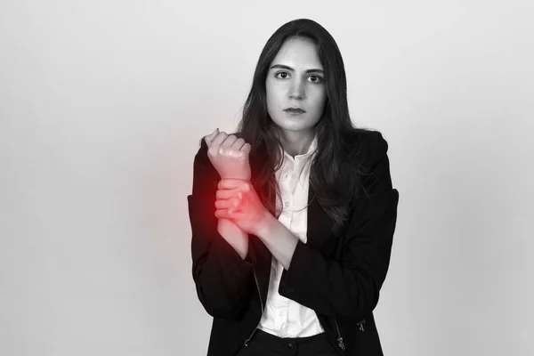 Junge Geschäftsfrau mit wund em Handgelenk in der Hand. schwarz-weiß mit rotem Akzent — Stockfoto
