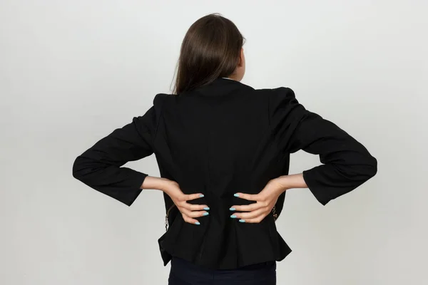 Mulher de negócios muito jovem sofre de dor nas costas — Fotografia de Stock