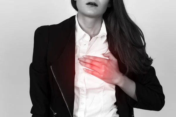 Schöne junge Geschäftsfrau mit Herzinfarkt oder gebrochenem Herzen. Schwarz-weiß mit rotem Akzent. Schmerzkonzept hautnah — Stockfoto