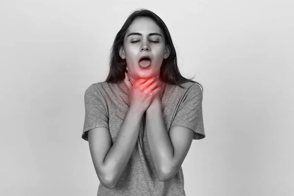 Junge Frau mit Halsschmerzen. schwarz-weiß mit rotem Akzent — Stockfoto