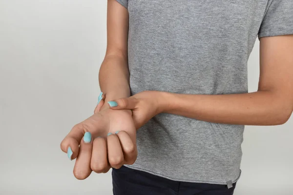 Frau hält wundes Handgelenk in der Hand. Schmerzkonzept hautnah — Stockfoto