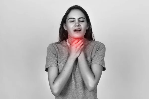 Junge Frau mit Halsschmerzen.. schwarz-weiß mit rotem Akzent — Stockfoto
