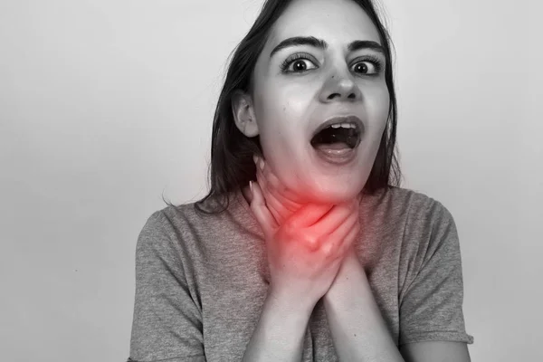 Junge Frau mit Halsschmerzen.. schwarz-weiß mit rotem Akzent. Schmerzkonzept hautnah — Stockfoto