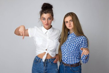 Gülümseyen güzel iki genç kız parmak aşağı dönük