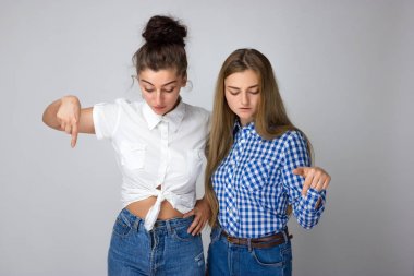 Gülümseyen güzel iki genç kız parmak aşağı dönük