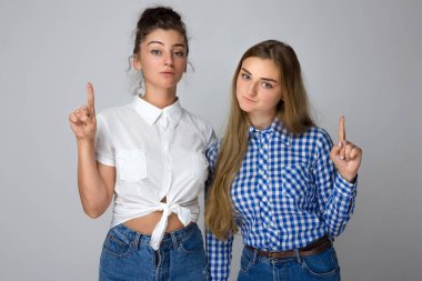 Ürün, gri arka plan üzerinde izole için yukarıyı mutlu iki genç kız kardeş