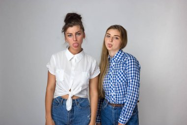 İki genç kız writhes yüzü gri arka plan üzerinde.