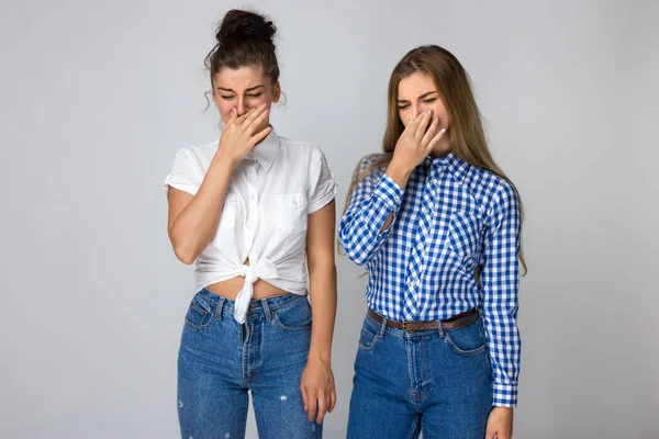 Retrato Dos Hermosas Hermanas Jóvenes Sobre Fondo Gris Sosteniendo Nariz —  Fotos de Stock