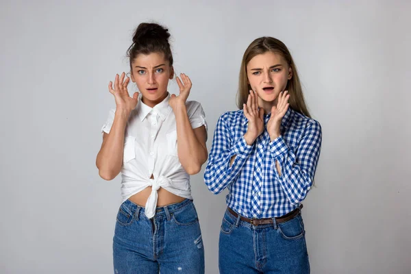 Dos Hermanas Jóvenes Sorprendidas Sobre Fondo Gris —  Fotos de Stock