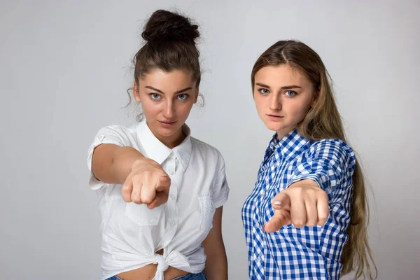 Δύο Νεαρές Αδελφές Δείχνοντας Κάμερα Δείκτη Απομονώνονται Γκρίζο Φόντο — Φωτογραφία Αρχείου