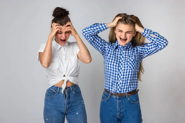 Retrato Dos Hermanas Jóvenes Disgustadas Enojado Sus Manos Pelo Rasgan —  Fotos de Stock