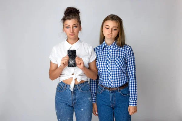 Две Грустные Юные Сестры Молодая Женщина Держит Смартфон Сломанным Экраном — стоковое фото