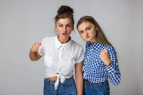 Zwei Junge Schwestern Zeigt Eine Faust Auf Grauem Hintergrund — Stockfoto