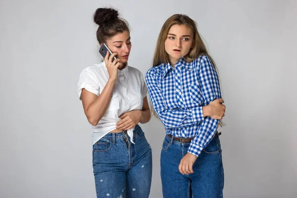 Dirsek ağrısı. Güzel dişi elbowher kardeşi tutan bir doktor gri arka plan üzerinde çağırıyor.