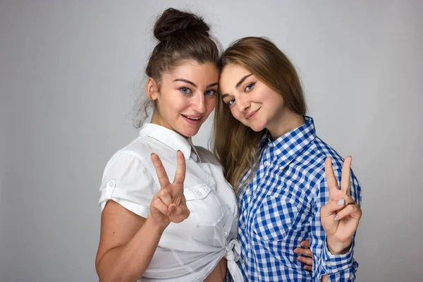 Deux Jeunes Sœurs Montrent Deux Doigts Sourient Sur Fond Gris — Photo