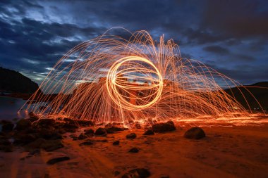 light lines of steel wool with long exposure, speed motion abstract background in the dark night clipart