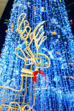 arka planda boyun ve mavi Noel ağacında kırmızı yay kravat ile Ren geyiği ampulü