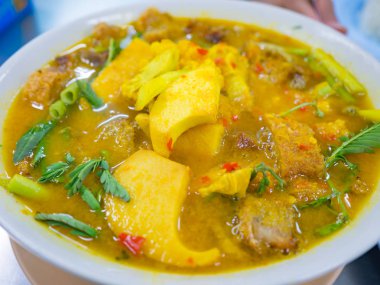 Gevrek domuz eti, taze organik su bakan sebze yeşil yaprakları ve Hindistan cevizi hurma ipucu Krachan Som (köri çorba yahnisi ekşi baharatlı türü)