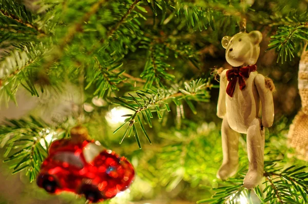 Christmas tree decorations. Small red car hanging on xmas tree. Teddy bear with red bow. — Stock Photo, Image