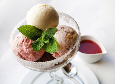 Ev yapımı dondurma vişne sos ile. Vanilya, çikolata, fındık.