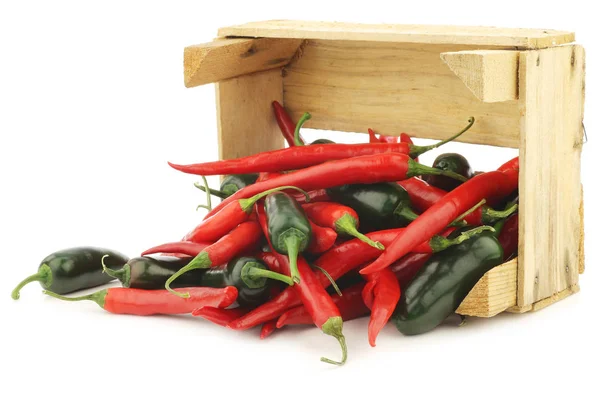 Red hot chili a zelené papriky (jalapeno) v dřevěné krabici — Stock fotografie