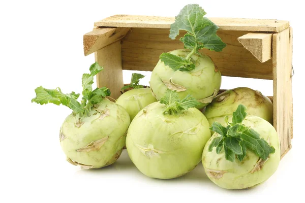 Kohlrabi recién cosechado con un poco de follaje en una caja de madera — Foto de Stock