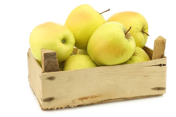 Fresh yellow apples and a cut one in a wooden crate — Stock Photo, Image