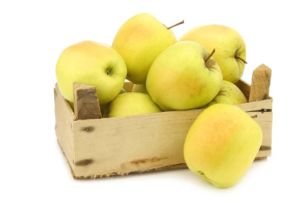 Fresh yellow apples and a cut one in a wooden crate — Stock Photo, Image