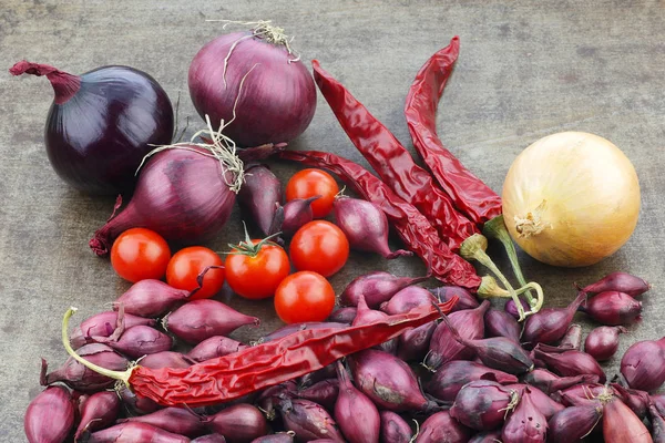 Farbenfrohe Präsentation von Zwiebeln, Tomaten und getrockneten Chilischoten — Stockfoto
