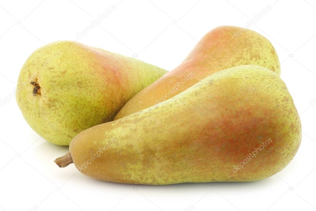 three fresh abate pears on a white background