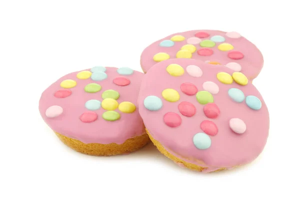 白い背景にピンクのアイシングとカラフルなスプリンクルでお祝いのケーキ — ストック写真